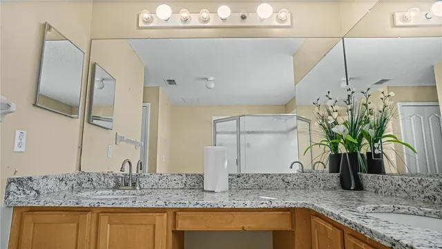 a bathroom with a granite countertop sink and a bathtub