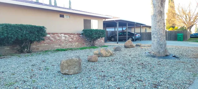 a backyard of a house with table and chairs