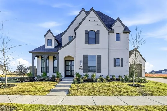 a view of a white house with large windows and a yard