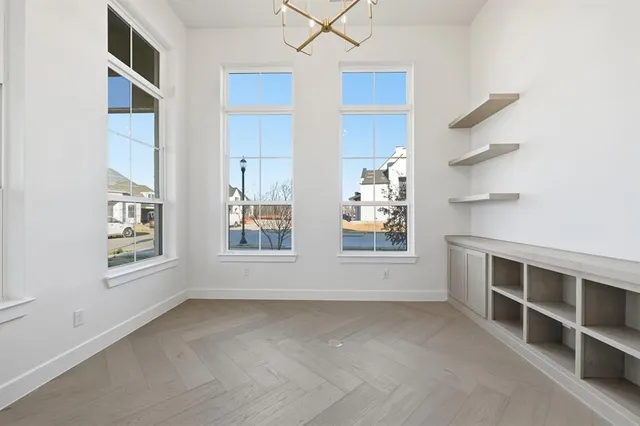 an empty room with windows on wall and white walls