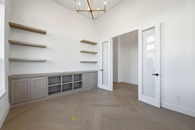 a view of an empty room with cabinet and entryway