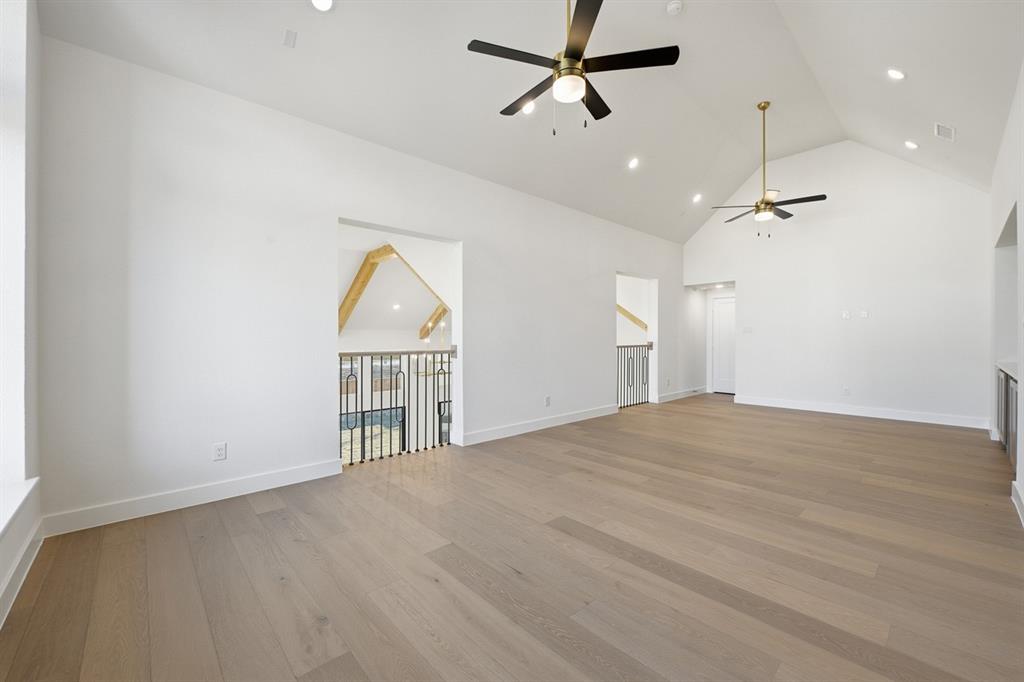 3700 Meander Way Prosper, TX 75078 - Photo 23 of 29 an empty room with wooden floor ceiling fan and windows