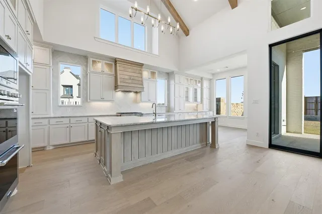 a kitchen with white cabinets and sink