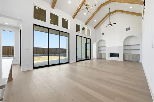 a view of an empty room with a fireplace and a window