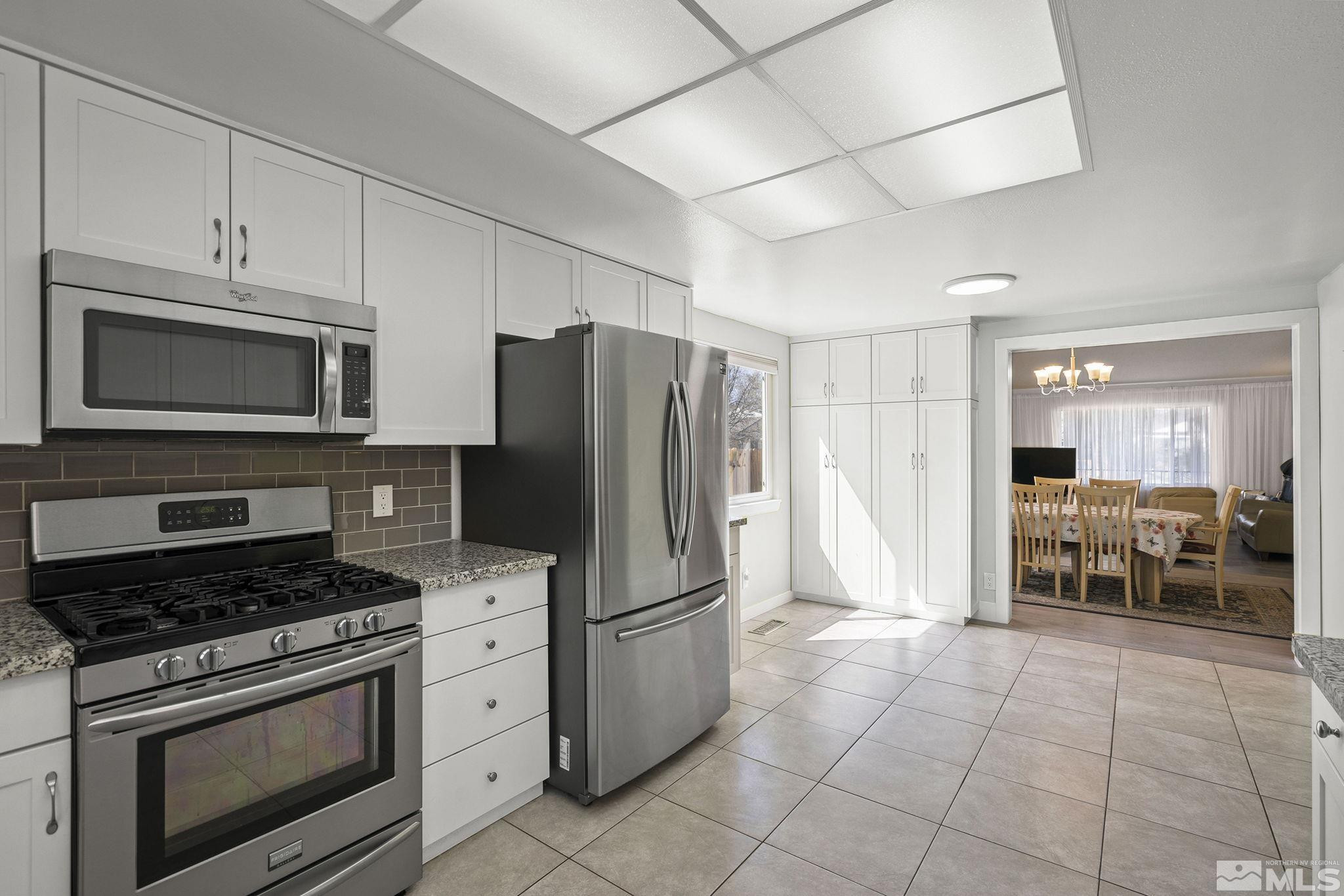 920 Pinebrook Road Reno, NV 89509 - Photo 13 of 40 a kitchen with granite countertop a refrigerator and a stove top oven