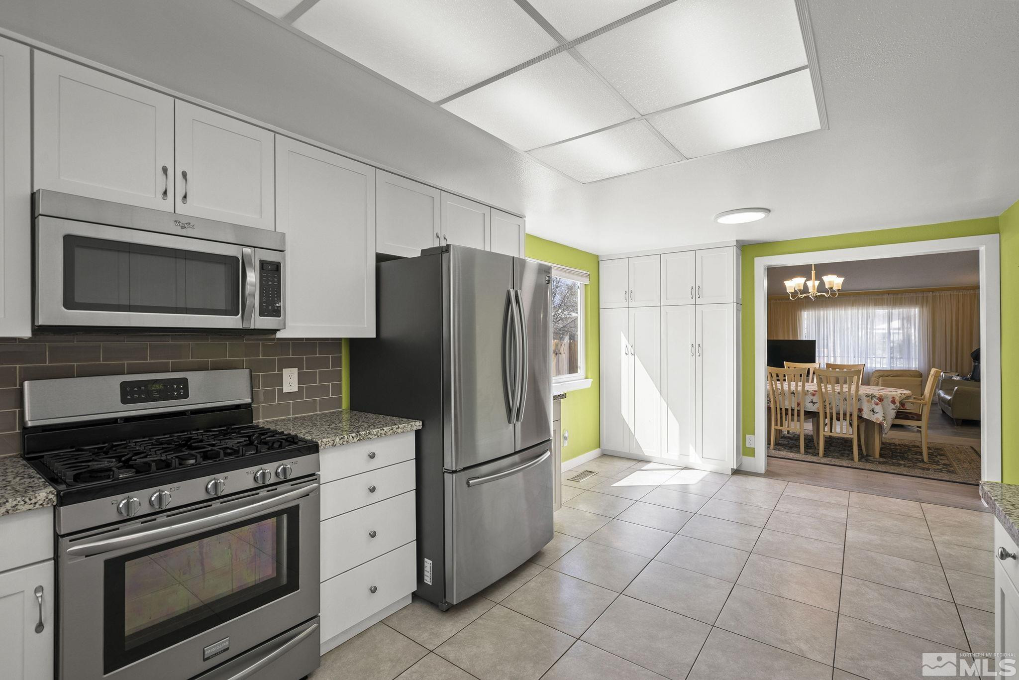 920 Pinebrook Road Reno, NV 89509 - Photo 15 of 40 a kitchen with granite countertop a refrigerator and a stove top oven