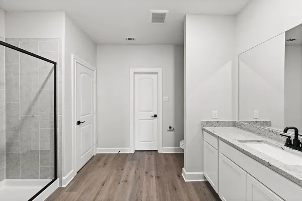 a bathroom with a granite countertop sink toilet and shower