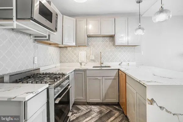 a kitchen with stainless steel appliances granite countertop a sink stove and cabinets