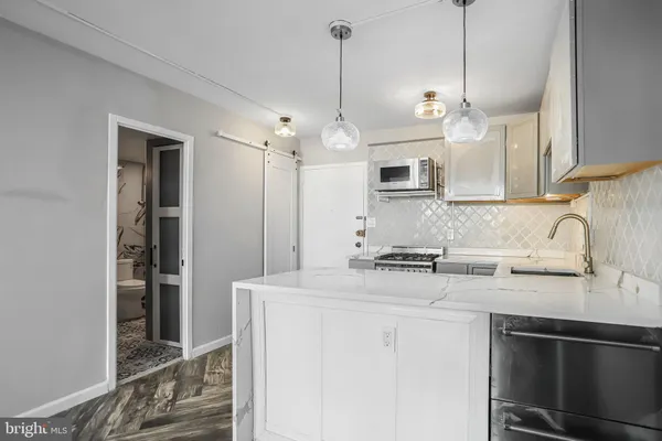 a kitchen with stainless steel appliances granite countertop a sink a stove and a refrigerator