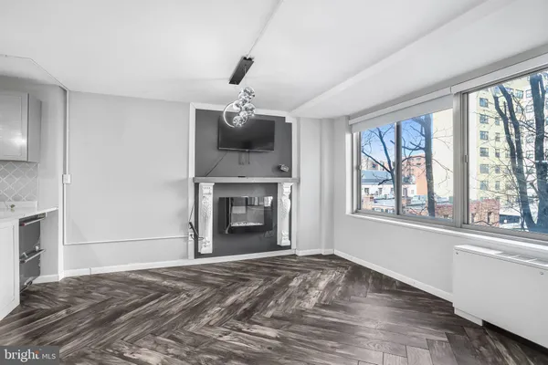 a view of an empty room with a window and fireplace