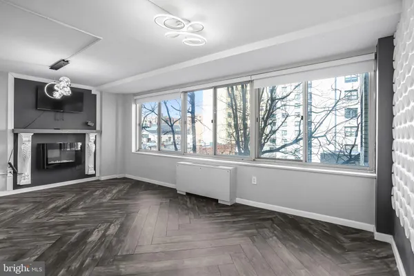 a view of an empty room with a window and fireplace