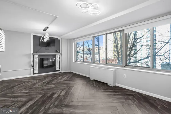 a view of an empty room with a window and fireplace