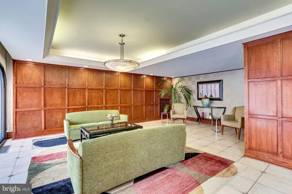 a living room with furniture a chandelier and a rug