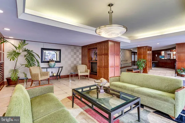 a living room with furniture a dining table and a chandelier