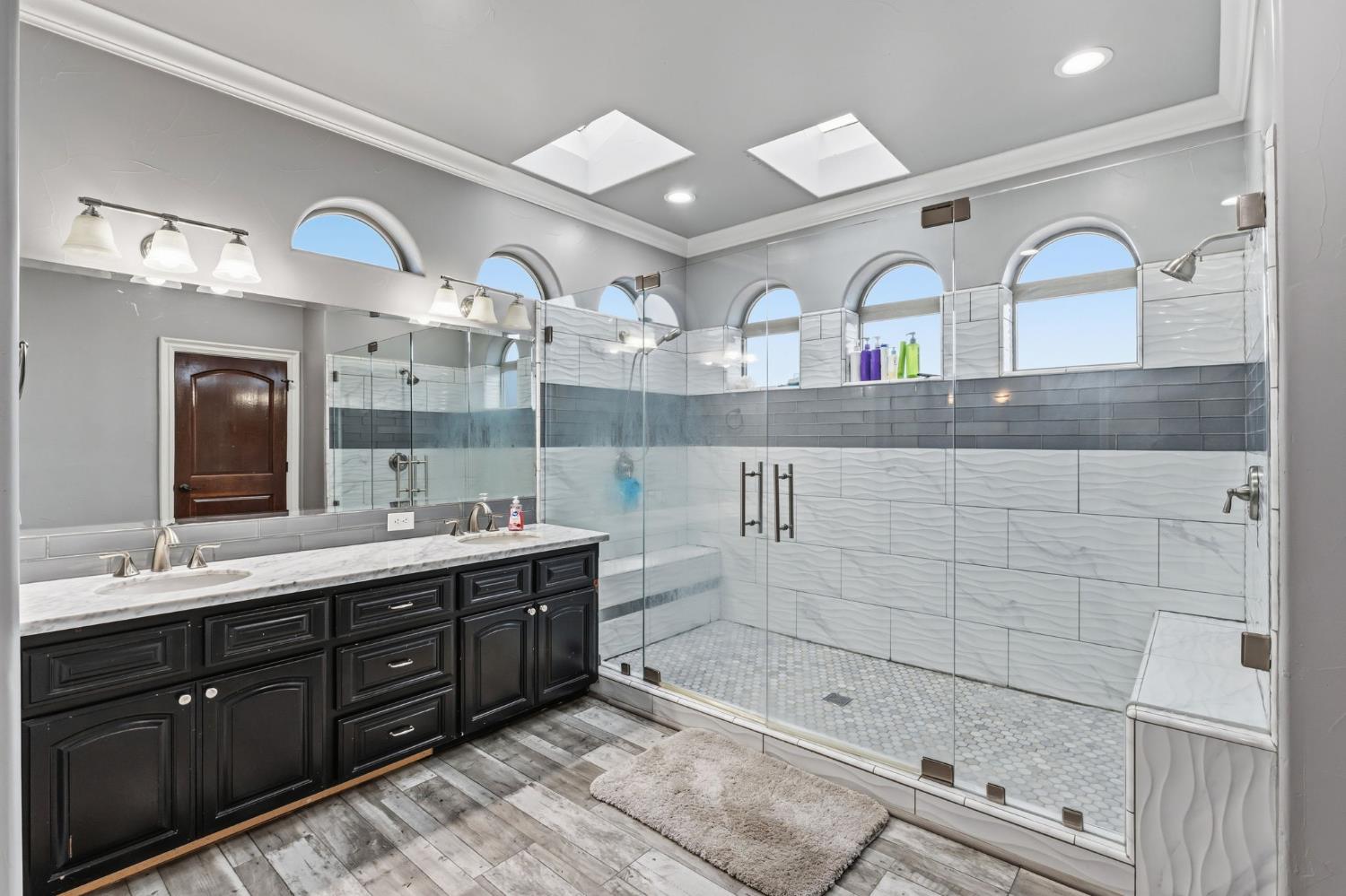 17703 El Camino Road Madera, CA 93636 - Photo 39 of 64 a bathroom with a double vanity sink a mirror and shower