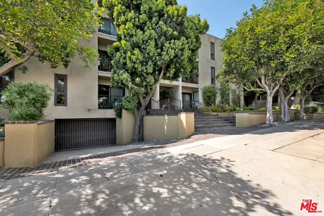 a front view of a multi story residential apartment building with a yard