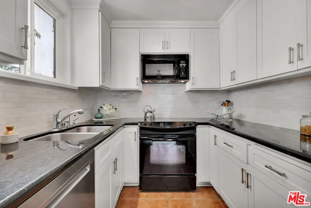 a kitchen with white cabinets and a stove top oven