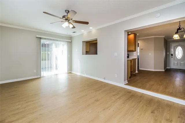 a view of an empty room with window and wooden floor