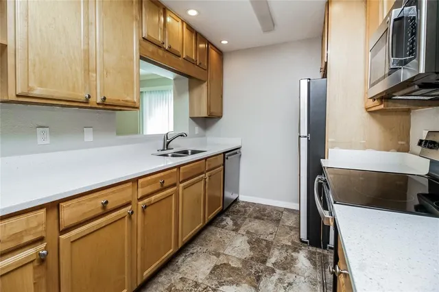 a kitchen with stainless steel appliances granite countertop a sink a stove and a refrigerator