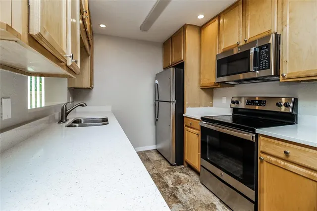 a kitchen with stainless steel appliances a stove a microwave a sink and cabinets