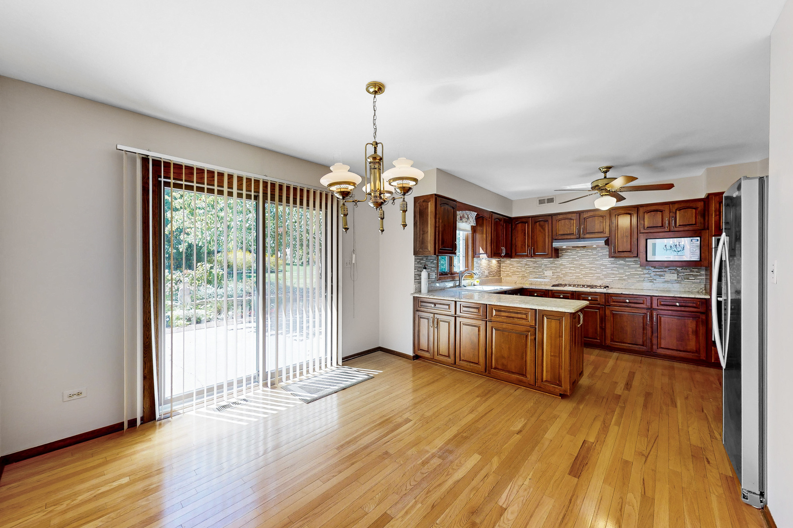 309 Hambletonian Drive Oak Brook, IL 60523 - Photo 6 of 39 a kitchen with stainless steel appliances granite countertop wooden floors sink and white cabinets