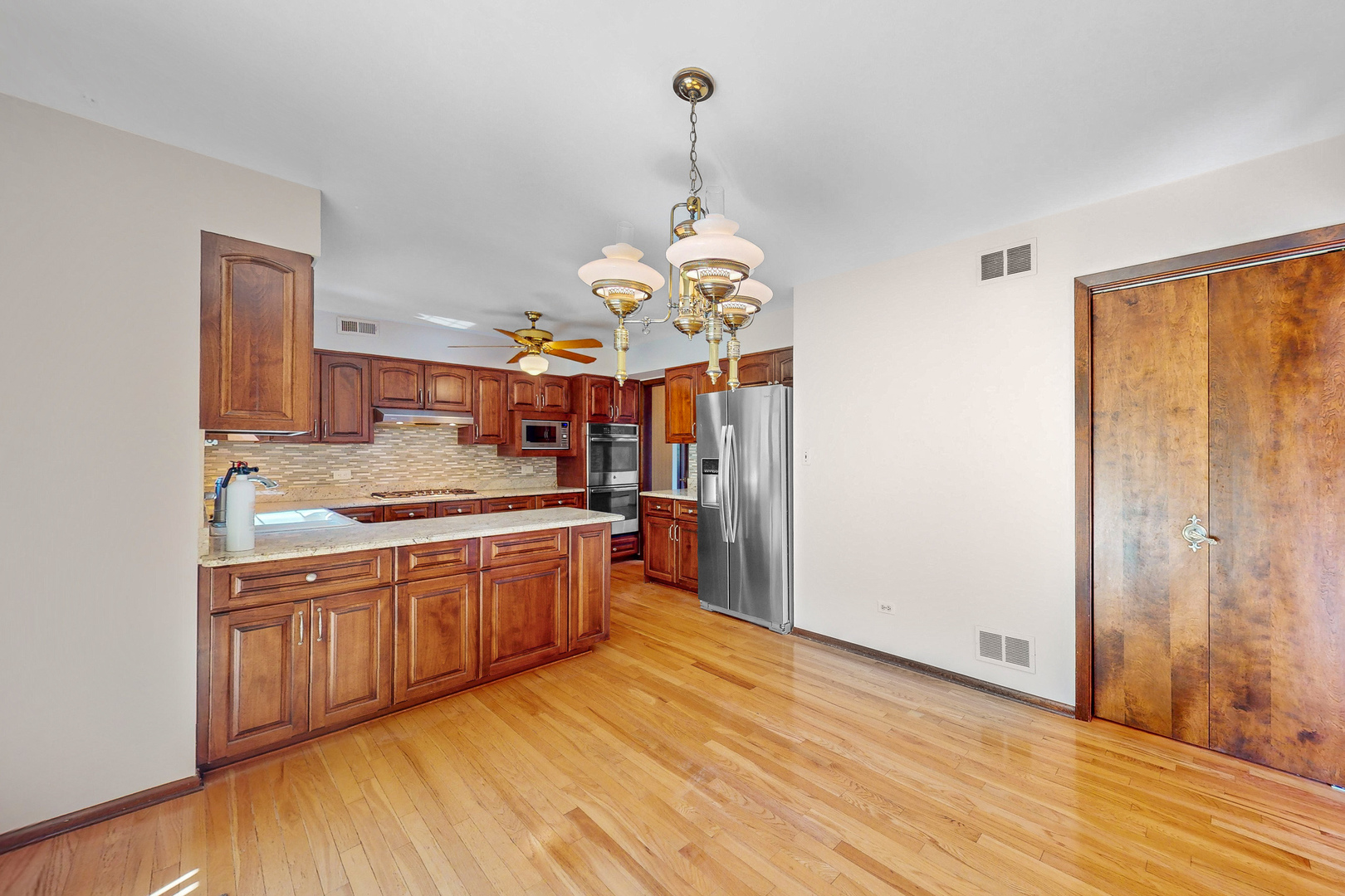 309 Hambletonian Drive Oak Brook, IL 60523 - Photo 7 of 39 a large kitchen with stainless steel appliances granite countertop a stove and a wooden floors