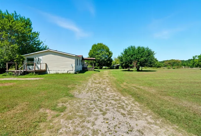 a view of a house with yard and green space