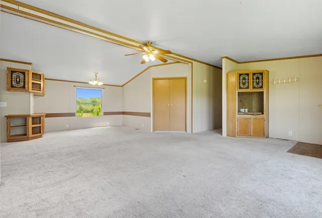 a view of a livingroom with an empty space and a kitchen