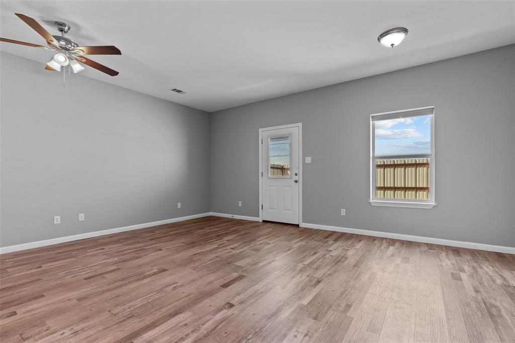 121 Winners Circle, Unit 102 Weatherford, TX 76087 - Photo 8 of 22 wooden floor in an empty room with a window