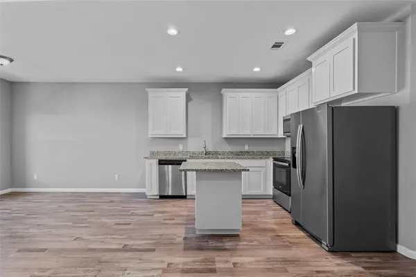 a kitchen with stainless steel appliances granite countertop a refrigerator sink and cabinets
