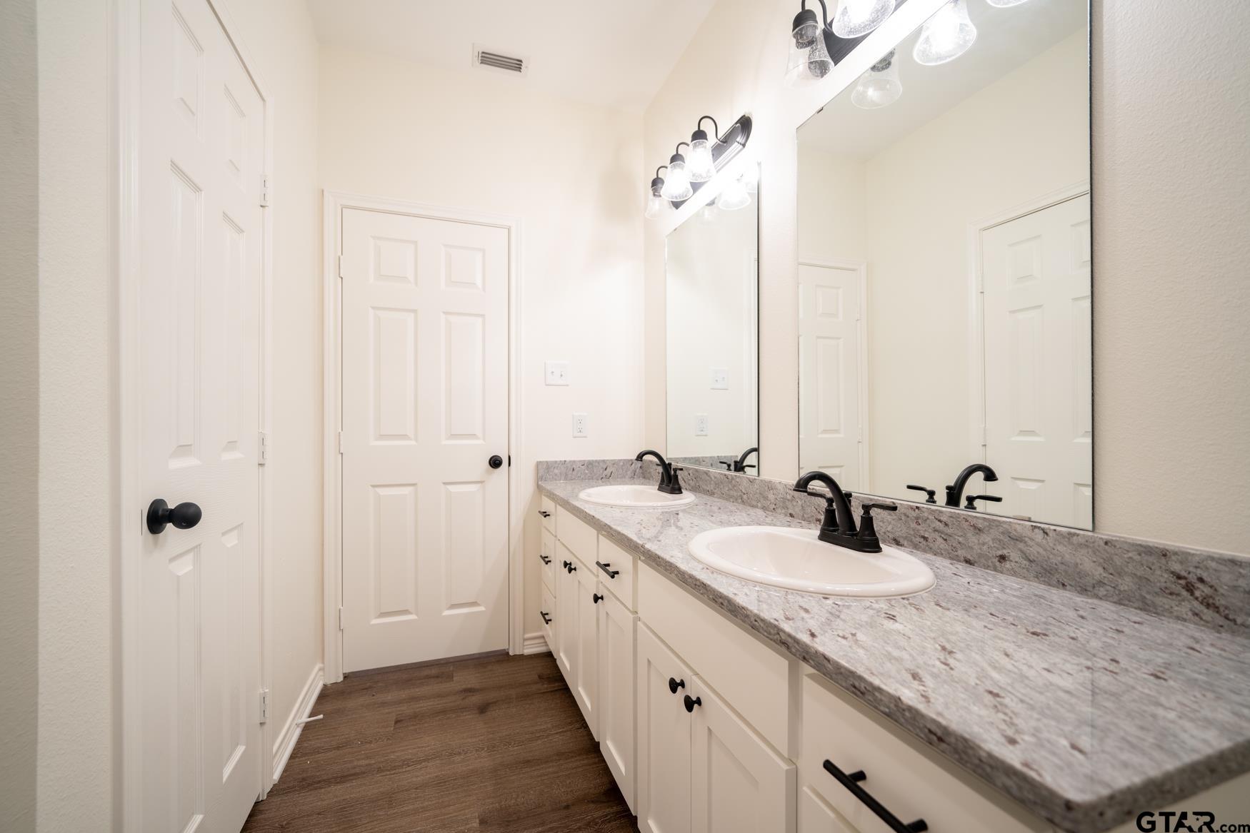 309 Stevens Street Gilmer, TX 75645 - Photo 14 of 28 a bathroom with 2 sink and a mirror