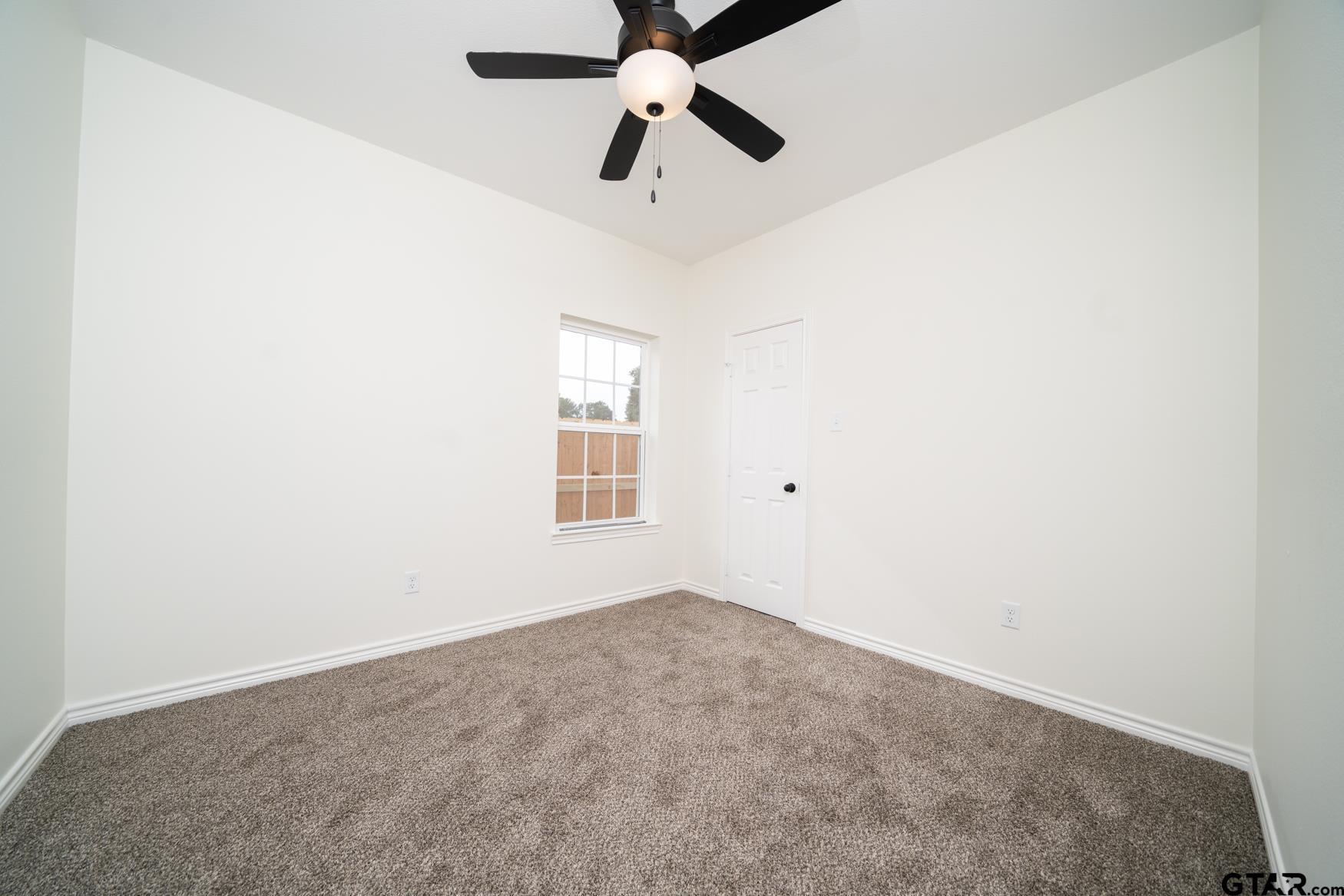 309 Stevens Street Gilmer, TX 75645 - Photo 16 of 28 an empty room with a window and a fan