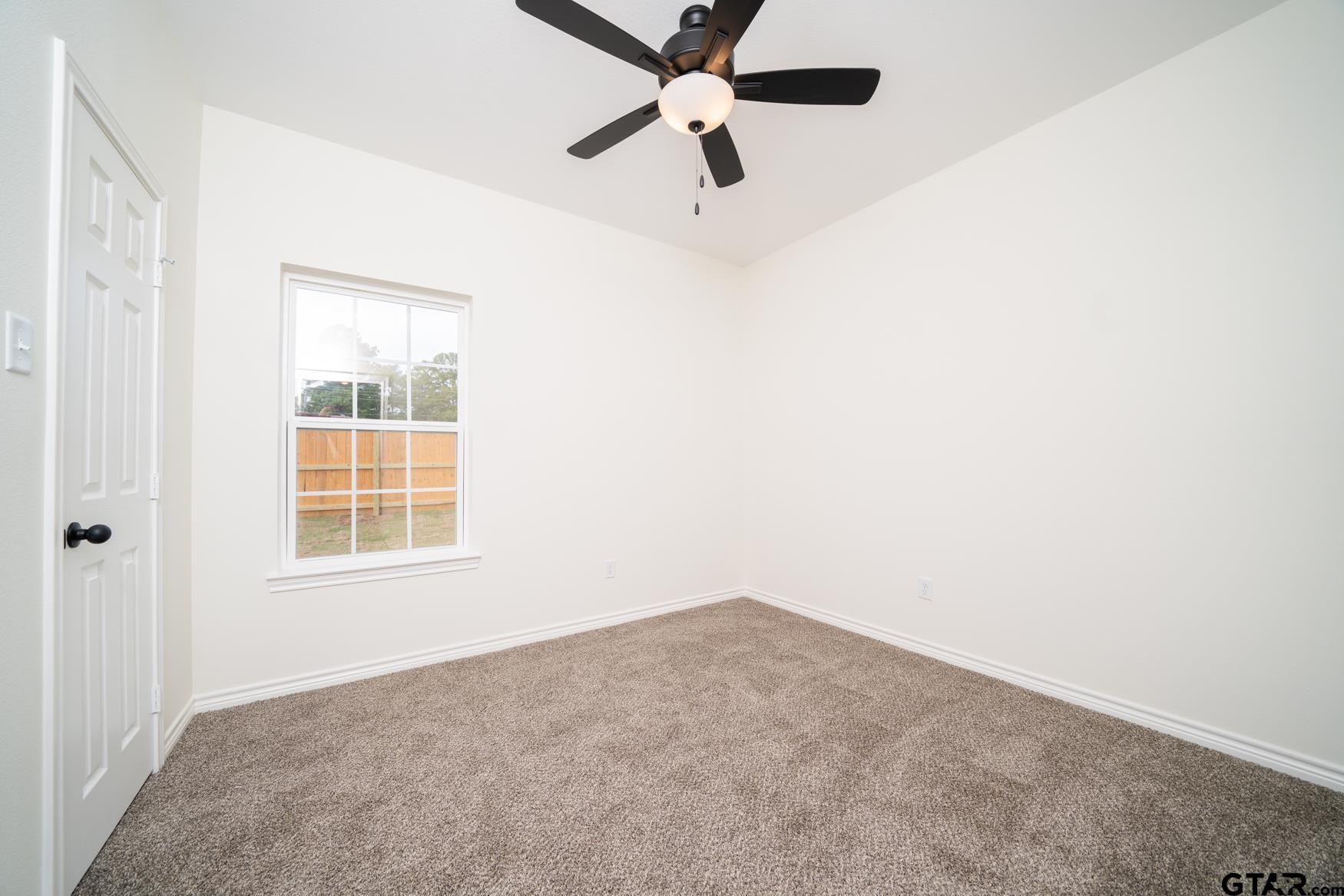 309 Stevens Street Gilmer, TX 75645 - Photo 17 of 28 an empty room with a window and a fan