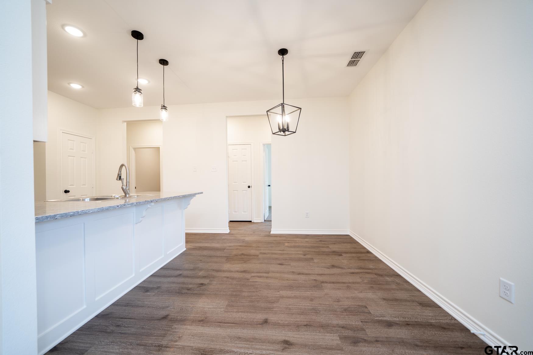 309 Stevens Street Gilmer, TX 75645 - Photo 6 of 28 a view of a kitchen with a sink and wooden floor