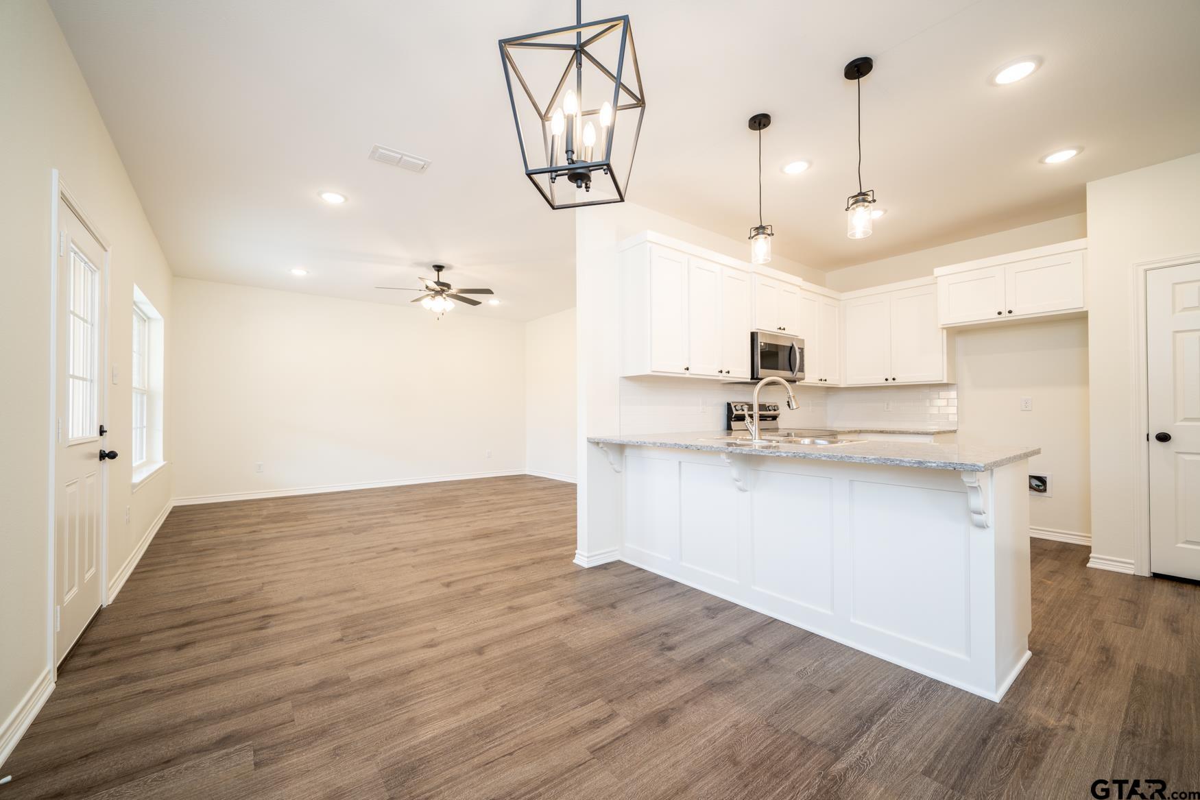 309 Stevens Street Gilmer, TX 75645 - Photo 7 of 28 a view of a kitchen with a sink a window and stainless steel appliances