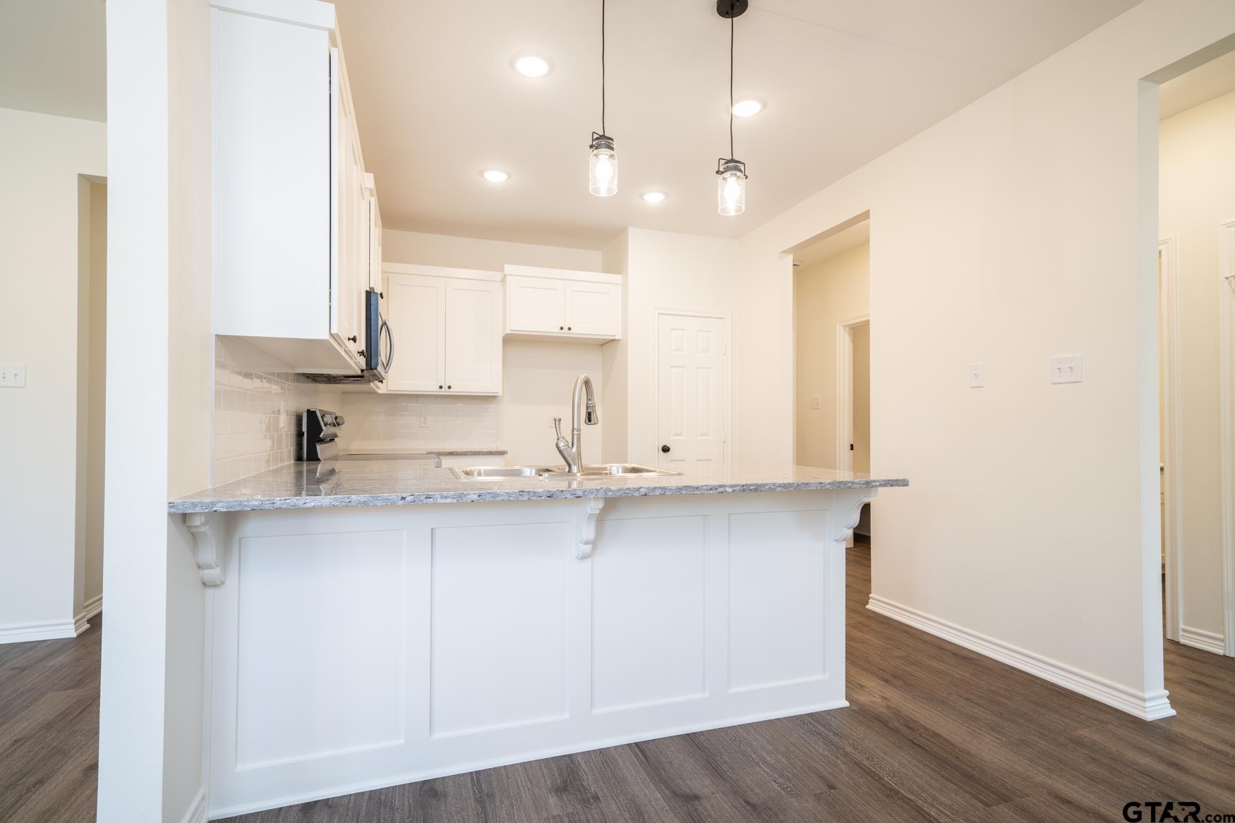 309 Stevens Street Gilmer, TX 75645 - Photo 8 of 28 a view of a kitchen with kitchen island a sink stainless steel appliances and cabinets