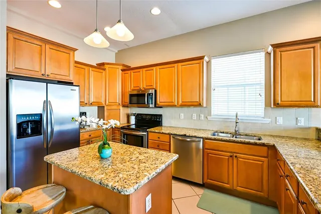 a kitchen with stainless steel appliances granite countertop a sink dishwasher stove refrigerator and microwave