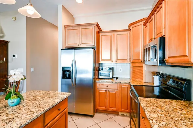 a kitchen with stainless steel appliances granite countertop a refrigerator a stove and a sink with granite countertops