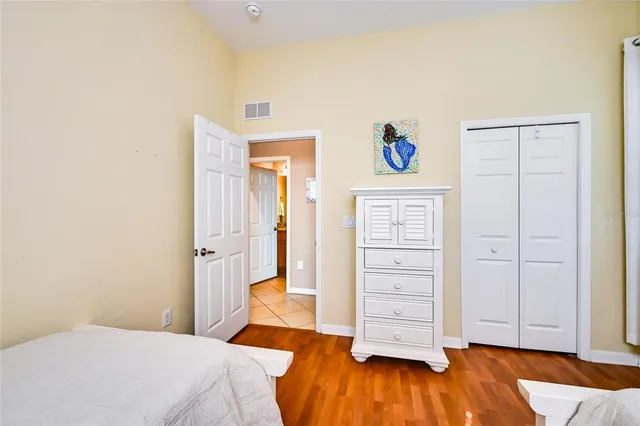 a bedroom with a bed and wooden floor
