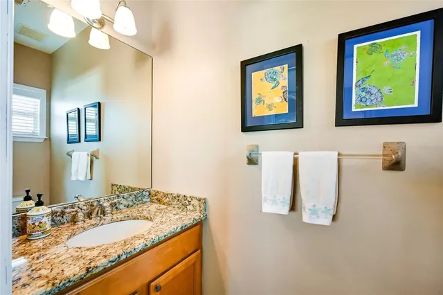a bathroom with a granite countertop sink a mirror and a shower