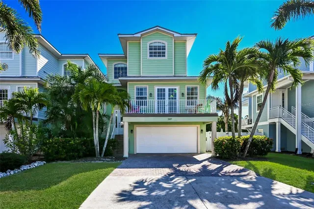 a view of a house with a yard plants and palm trees