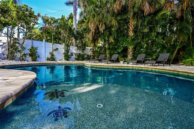 a view of a swimming pool with a yard and sitting area