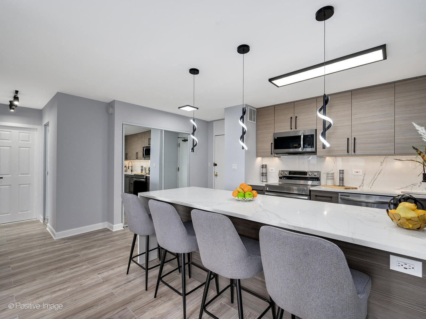 5455 North Sheridan Road, Unit 3906 Chicago, IL 60640 - Photo 11 of 24 a kitchen with stainless steel appliances a stove a refrigerator a sink dishwasher a dining table and chairs with wooden floor