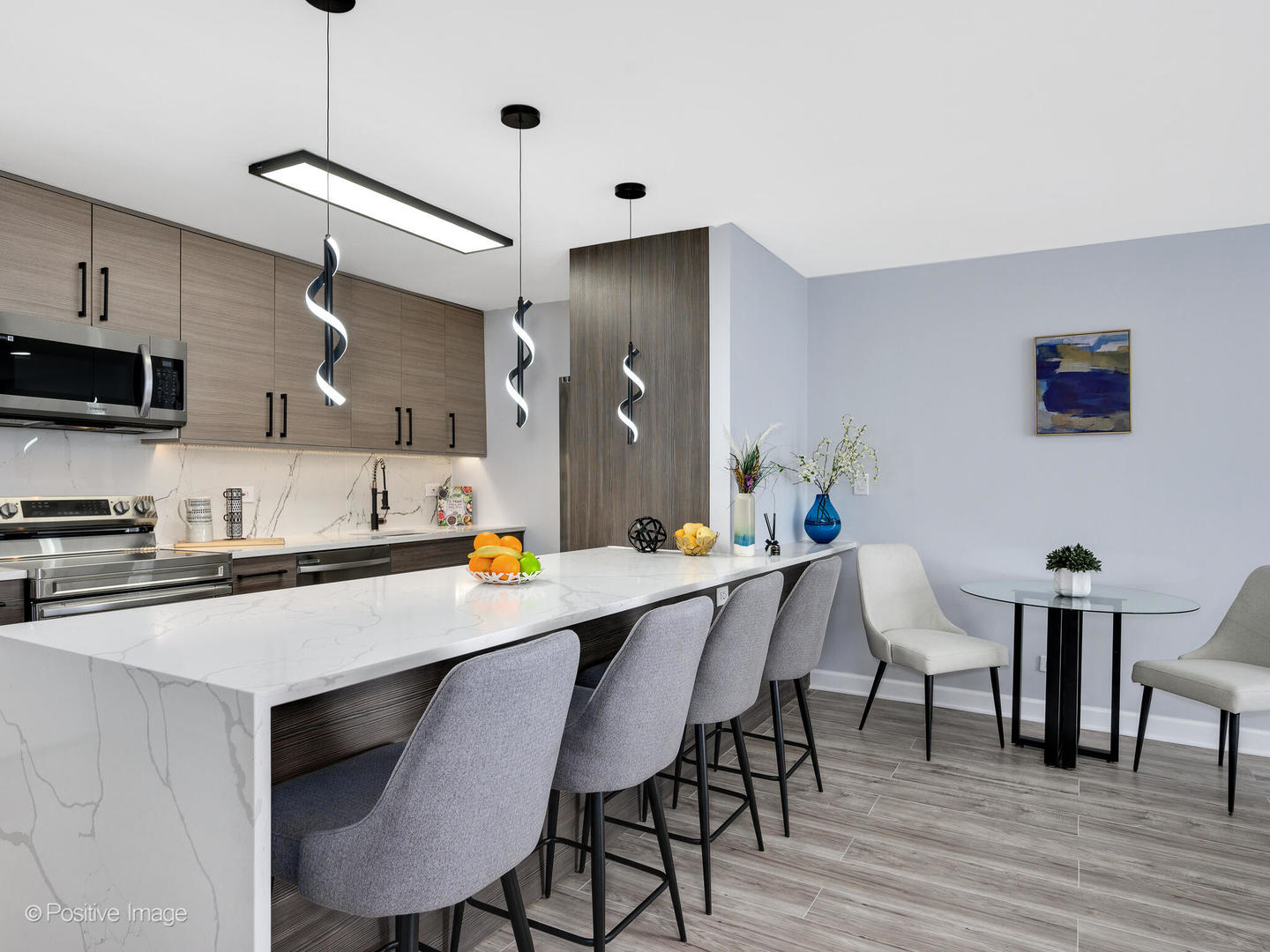 5455 North Sheridan Road, Unit 3906 Chicago, IL 60640 - Photo 6 of 24 a kitchen with stainless steel appliances a table chairs refrigerator and sink