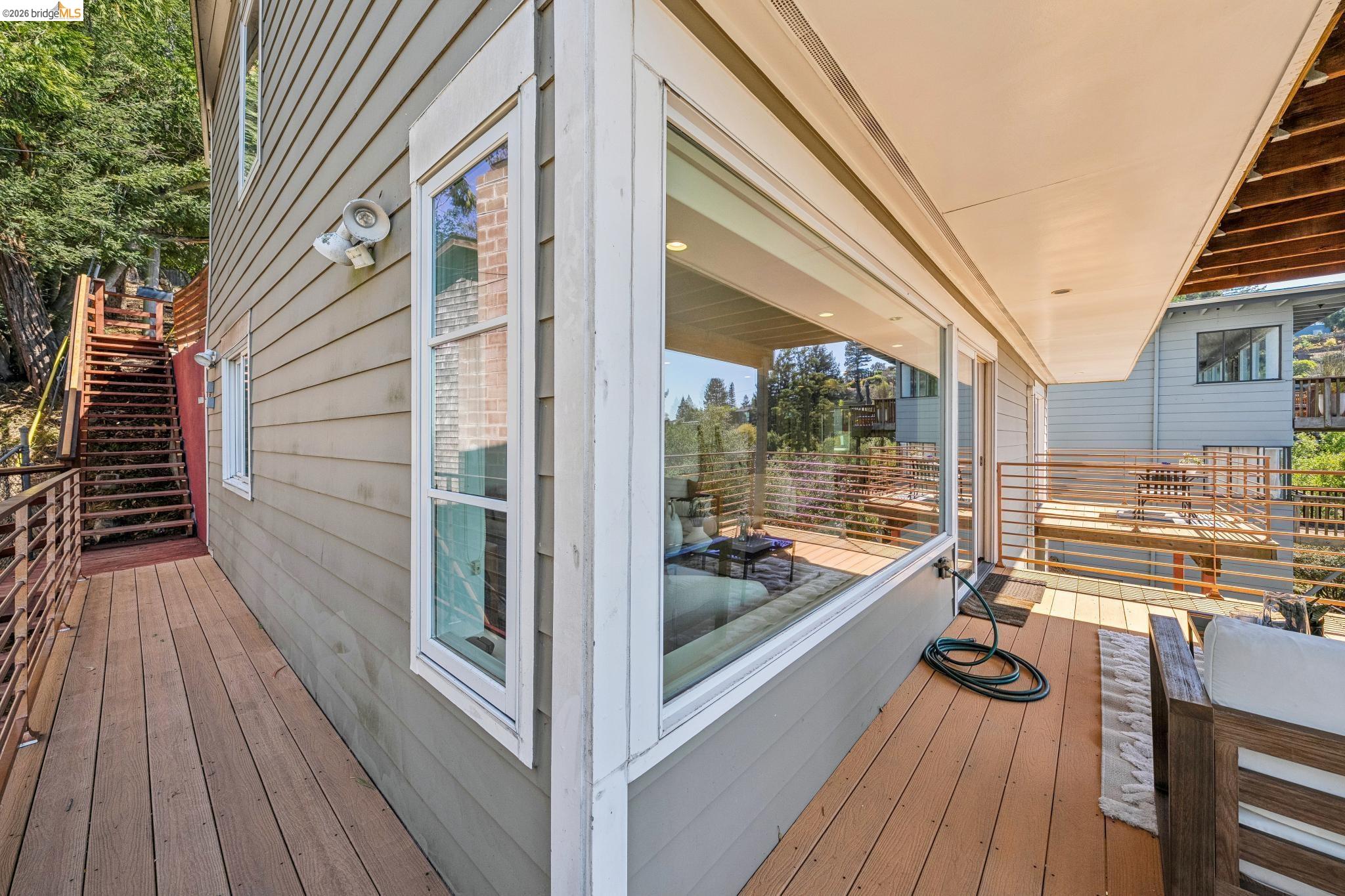 1394 Queens Road Berkeley, CA 94708 - Photo 59 of 63 Exterior deck with wood-finish flooring, full-lite sliding glass door, and a horizontal metal railing system