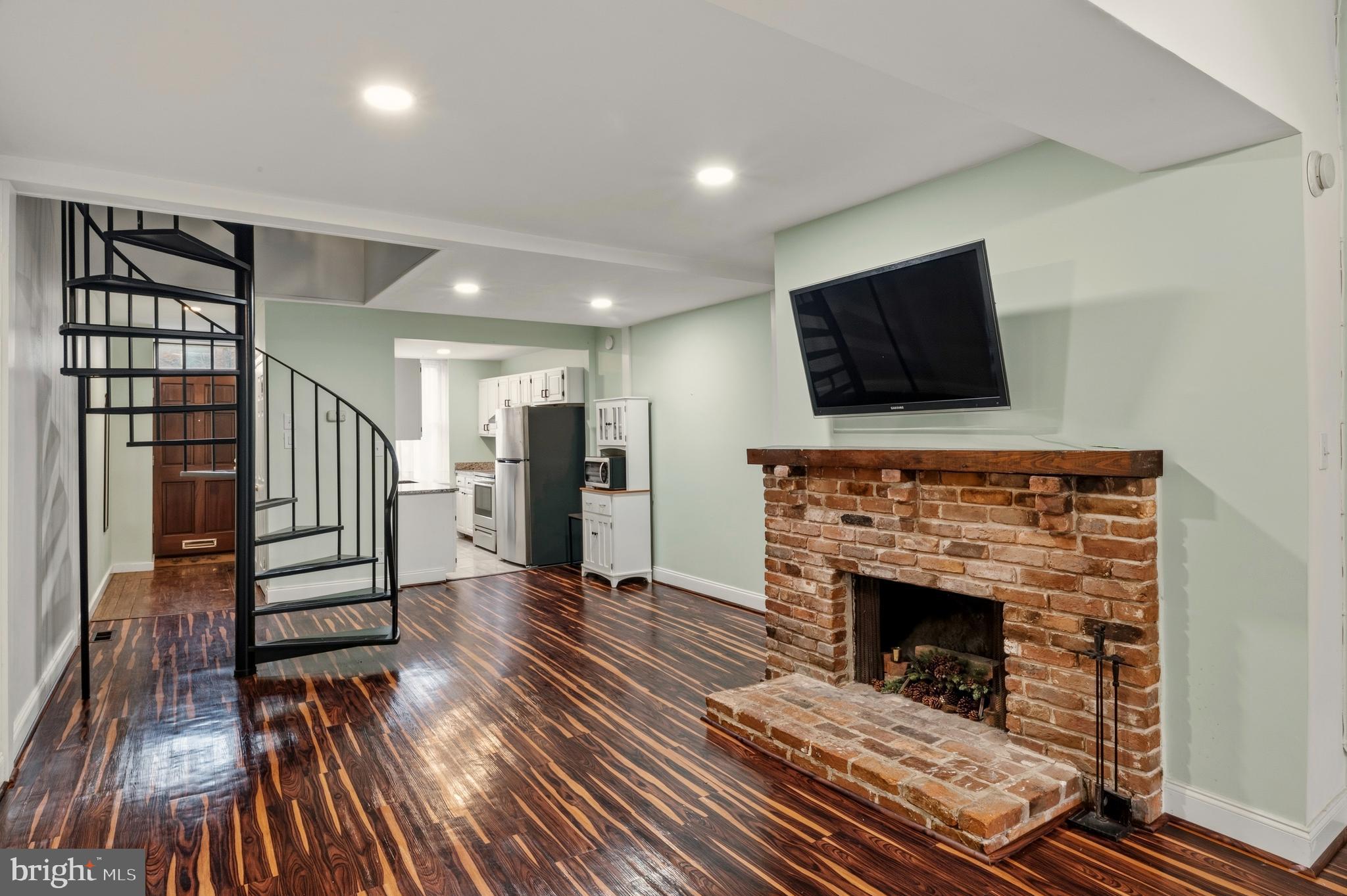 636 Portland Street Baltimore, MD 21230 - Photo 4 of 20 a living room with furniture a flat screen tv and a fireplace
