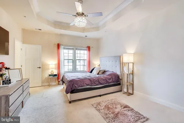 a spacious bedroom with a bed and a chandelier