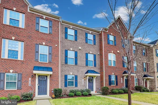 a front view of a brick building next to a yard