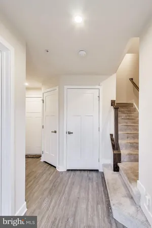 a view of hallway with stairs and wooden floor