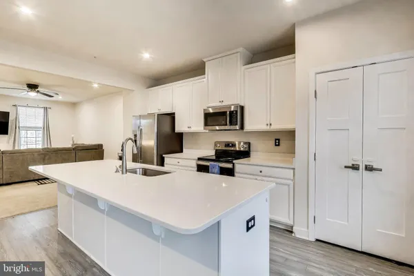 a kitchen with a sink a stove a refrigerator and white cabinets